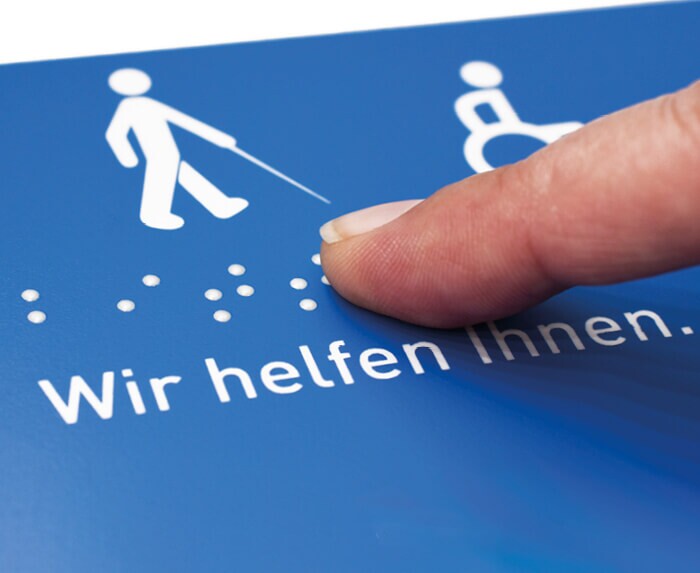 Finger zeigt auf Blindenschrift / Brailleschrift