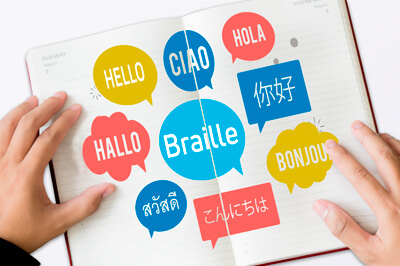 Hände, die ein Buch mit verschiedenen Sprachen ertasten