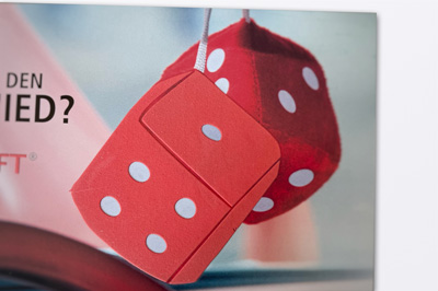 Rote hängende Stoffwürfel und man sieht auf dem vorderen Würfel die Zahlen vier und eins und auf dem hinteren Würfel die zwei