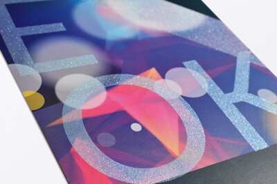 Ausschnitt eines Flyers mit buntem Hintergrund und Typografie