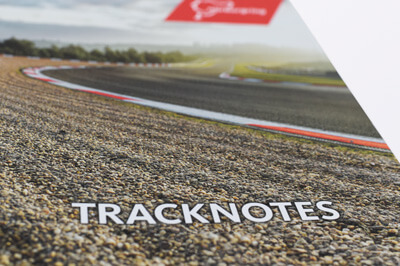 Postkarte auf der man Kies an der Seite einer Rennstrecke sieht