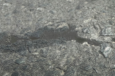 Ein Bild auf dem eine gefrorene Pfütze zu sehen ist, bei der das Eis langsam gebrochen ist