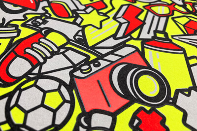 Postkarte mit verschiedenen Motiven, in Neon gelb, rot, grau und schwarz abgebildet. Man sieht einen Fußball, Sneakers, Fotokamera, Sprühdose, Stern, Brille und alle Motive sind durcheinander abgebildet.