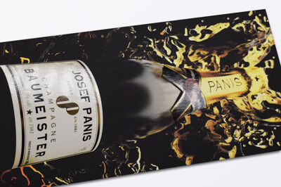 Flyer auf dem eine Champagnerflasche mit UV-Lackierung zu sehen ist.