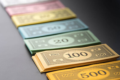 Farbige, nebeneinander aufgereihte Spielzeug-Geldscheine